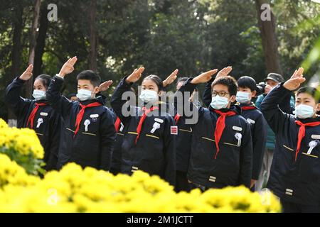 NANJING, CHINE - 13 DÉCEMBRE 2022 - les élèves du primaire saluent les jeunes pionniers au monument des victimes du massacre de Nanjing par le Japon Banque D'Images