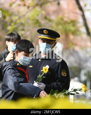 NANJING, CHINE - le 13 DÉCEMBRE 2022 - les gens jettent des fleurs sur un monument pour les victimes du massacre de Nanjing par les troupes japonaises près de l'Arctic Pavil Banque D'Images