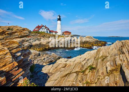 Côte rocheuse sans fin avec grand phare blanc dans le Maine Banque D'Images