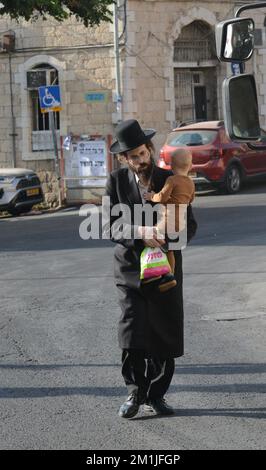 Un homme Haredi tenant sa petite fille dans le quartier de MEA Shearim à Jérusalem. Banque D'Images