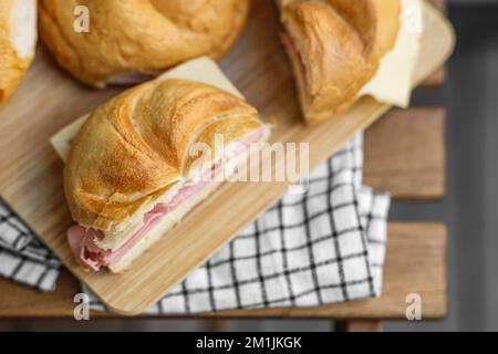 Délicieux petits pains kaiser avec jambon et fromage sur la table Banque D'Images