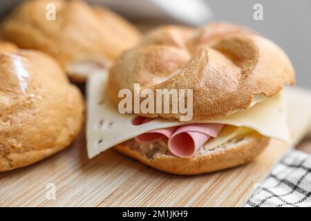 Petits pains Kaiser avec jambon et fromage sur bois Banque D'Images