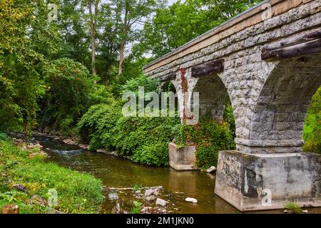 Rivière avec d'énormes arches de pierre de la voie de train pont traversant Banque D'Images