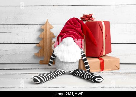 Jouet de gnome de Noël, boîtes-cadeaux et décor sur fond de bois clair Banque D'Images