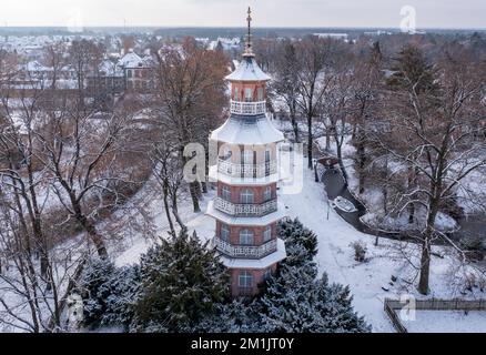 Oranienbaum, Allemagne. 12th décembre 2022. La pagode se trouve dans le jardin enneigé anglais-chinois du Palais Oranienbaum. Construit en 1683 comme résidence d'été pour la princesse Henriette Catharina, épouse du prince Johann Georg II d'Anhalt-Dessau et princesse d'Orange-Nassau de naissance, le palais a été restauré morceau par morceau depuis des années. Avec son magnifique jardin, il fait partie du Royaume des jardins de Dessau-Wörlitz, site classé au patrimoine mondial de l'UNESCO. (Vue aérienne avec drone) Credit: Jan Woitas/dpa/Alamy Live News Banque D'Images