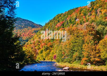 Feuillage d'automne dans New York lignes rivière peu profonde avec des montagnes à distance Banque D'Images