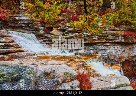 Belles couches de rochers dans la rivière avec cascades et arbres d'automne Banque D'Images