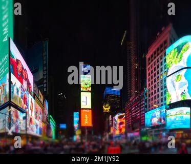 Vue panoramique de l'emblématique Times Square à New York avec des publicités et des touristes flous Banque D'Images