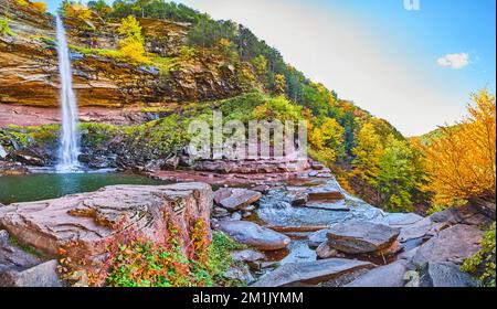 Vue panoramique depuis le dessous de la cascade sur les falaises et le feuillage d'automne, le sentier de randonnée et les touristes Banque D'Images