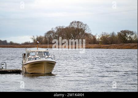 un petit yacht à moteur amarré sur la rive de la rivière Banque D'Images