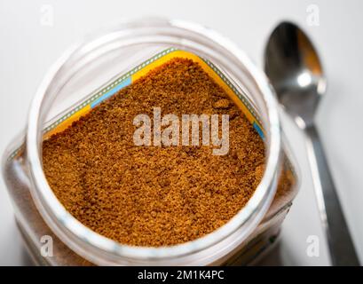 Sucre de noix de coco dans un récipient en plastique sur fond blanc. Banque D'Images