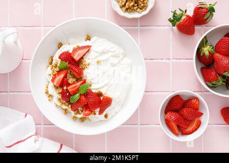 Yaourt à la fraise. Yaourt grec blanc Uni aux baies fraîches et au granola. Nourriture saine, petit déjeuner. Vue de dessus Banque D'Images