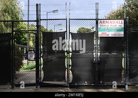 Entrée ouest du club de boules Armadale, sur Nelson St, avec panneaux, escrime noire et barbelés Banque D'Images