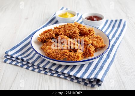 Filets de poulet faits maison avec moutarde et barbecue sur une assiette, vue latérale. Banque D'Images