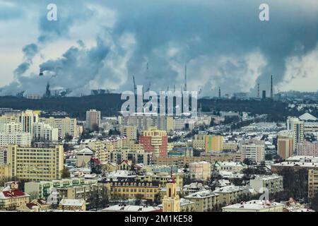 ariel vue panoramique de la ville avec une immense usine avec cheminées fumeurs en arrière-plan Banque D'Images