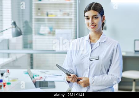 Portrait à la taille de la femme souriante du Moyen-Orient debout dans un laboratoire médical, espace de copie Banque D'Images