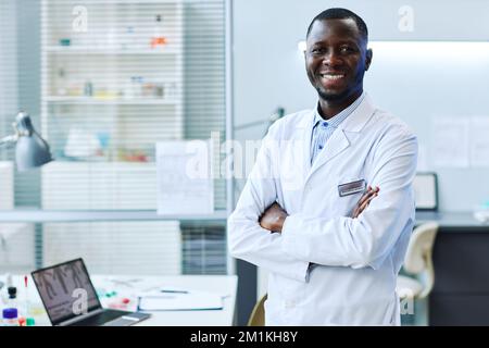 Portrait à la taille de l'homme noir souriant debout dans un laboratoire médical, espace de copie Banque D'Images
