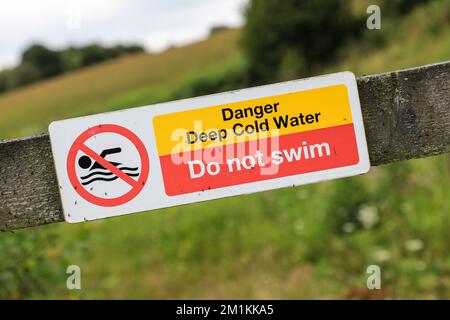 Un panneau d'avertissement indiquant « Anger Deep Cold Water », « ne pas nager », Angleterre, Royaume-Uni Banque D'Images
