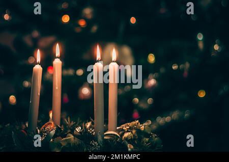 bougies allumées sur les couronnes de l'avent avec fond d'arbre de noël Banque D'Images