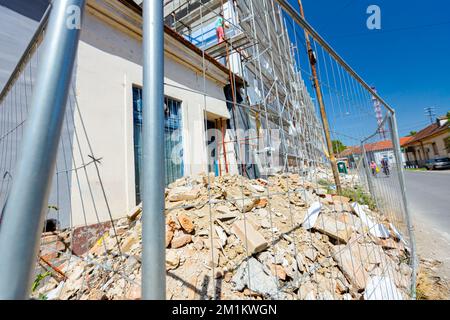 Gros plan d'une clôture métallique en fil métallique placée devant le chantier de construction à côté de la rue, bâtiment résidentiel en construction. Banque D'Images