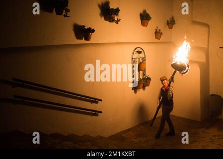 Malaga, Espagne, 12/12/2022, Un villageois est vu tenir une torche dans la rue pendant qu'elle participe à la célébration de la procession de la Vierge de 'Divina Pastora'. La veille de la fête de Saint Lucia dans le petit village de Casarabonela, chaque nuit du 12 décembre pendant la saison de Noël, les villageois prennent part à la célébration antique de 'Los Rondeles' portant des paniers de wckers en feu (également connu sous le nom de 'rondeles') trempés dans l'huile. Le long des rues, la Vierge de 'Los Rondeles' est honorée par les dévotés dans un rituel de lumière et de feu comme action de grâce pour la récolte obtenue. Banque D'Images