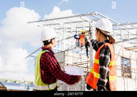 Retour deux architectes et client discutant aider à créer un plan avec le projet de construction de maison sur le site de construction Banque D'Images