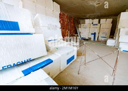 Emballages de matériaux d'isolation thermique, polystyrène, enveloppés dans du papier d'aluminium en attente d'installation sur les murs, placés dans l'entrepôt. Banque D'Images