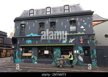 Un nettoyeur de rue poussant son chariot vers le haut de North Road dans le secteur de Laine Nord de Brighton. Banque D'Images