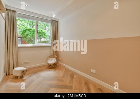 une pièce vide avec parquet et murs beige, garniture blanche autour de la fenêtre pour créer une sensation naturelle Banque D'Images