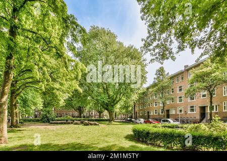 un complexe d'appartements avec des arbres dans la cour et des pelouses des deux côtés il y a un ciel bleu vif au-dessus Banque D'Images