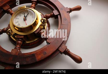 Voilier Helm en bois rouge avec cadre en cuivre horloge sur fond blanc Banque D'Images