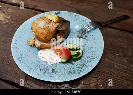 Le flétan poisson sur une table en bois dans un restaurant bon marché. Banque D'Images