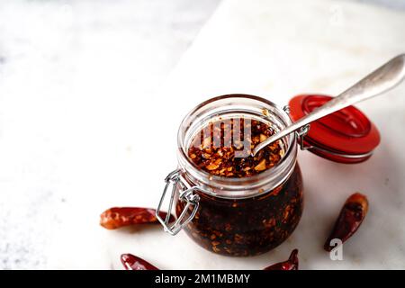 Huile de Chili asiatique maison dans un pot en verre, mise au point sélective Banque D'Images