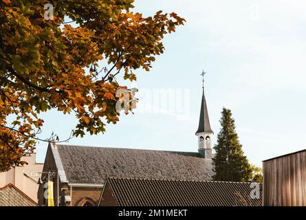 Hasselt, Limbourg-Belgique. 20-10-2021. Un petit bâtiment d'église dans le centre-ville. Fragment du toit sur fond d'automne Banque D'Images