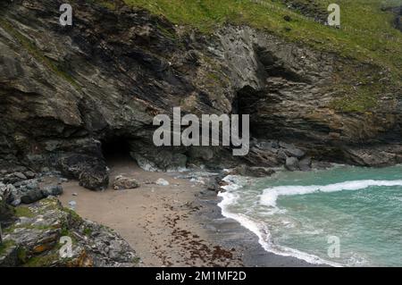 Merlin's Cave sous le château sur l'île de Tintagel depuis Tintagel Haven sur le South West Coastal Path à Cornwall, Angleterre, Royaume-Uni. Banque D'Images