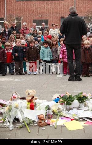 20120316 - HEVERLEE, BELGIQUE: Enfants sur le terrain de jeu devant des fleurs, des ours en peluche et des bougies pendant la minute de silence le jour du deuil national belge, autour de l'école primaire (école primaire de bassime) Sint-LambertussSchool, à Heverlee, vendredi 16 mars 2012. Dans un terrible accident de bus mardi soir dans un tunnel, à Sierre, Valais, Suisse, 28 personnes, dont 22 enfants, morts, 24 autres blessés. Les enfants, de deux écoles de Lommel et de Heverlee, rentrent chez eux après des vacances de ski. BELGA PHOTO CHRISTOPHE LEGASSE Banque D'Images