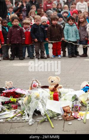 20120316 - HEVERLEE, BELGIQUE: Enfants sur le terrain de jeu devant des fleurs, des ours en peluche et des bougies pendant la minute de silence le jour du deuil national belge, autour de l'école primaire (école primaire de bassime) Sint-LambertussSchool, à Heverlee, vendredi 16 mars 2012. Dans un terrible accident de bus mardi soir dans un tunnel, à Sierre, Valais, Suisse, 28 personnes, dont 22 enfants, morts, 24 autres blessés. Les enfants, de deux écoles de Lommel et de Heverlee, rentrent chez eux après des vacances de ski. BELGA PHOTO CHRISTOPHE LEGASSE Banque D'Images