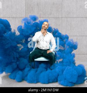 homme pensif assis enveloppé de fumée bleue, concept de créativité Banque D'Images