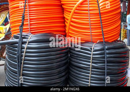 stock de tuyaux en plastique de couleur noire et orange en magasin pour la vente Banque D'Images