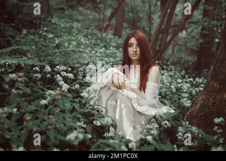 Belle fille aux cheveux rouges dans la forêt secrète Banque D'Images