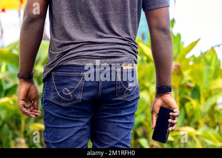 jeune homme africain tenant un smartphone sur le chantier Banque D'Images