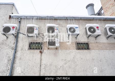 Riga, Lettonie - 12 décembre 2022 : les climatiseurs de différentes marques montés sur le mur sont congelés et recouverts de glaçons. Banque D'Images