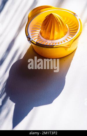 Presse manuelle presse manuelle presse manuelle presse-agrumes presse-agrumes. Jaune Orange plastique blanc lampe de table soleil extraction belle Banque D'Images