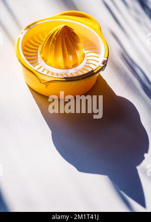 Presse manuelle presse manuelle presse manuelle presse-agrumes presse-agrumes. Jaune Orange plastique blanc lampe de table soleil extraction belle Banque D'Images