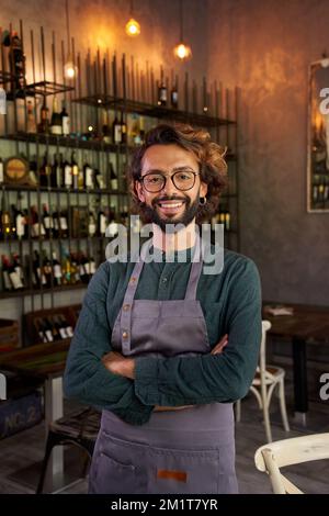 Portrait vertical regardant le portrait d'appareil photo de jeune propriétaire d'une petite entreprise locale.gaie homme travailleur souriant Banque D'Images