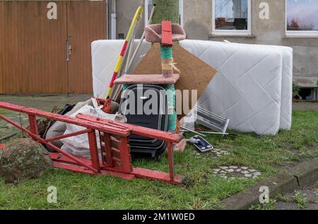 Tas de déchets volumineux avec matelas, planche à repasser et échelle rouge Banque D'Images