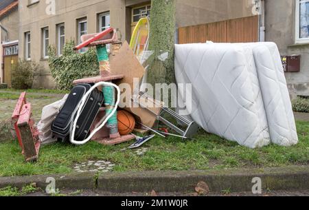 Tas de déchets volumineux avec matelas, planche à repasser et échelle rouge Banque D'Images