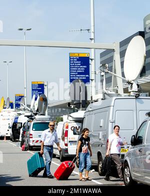 L'illustration montre des fourgonnettes satellites et des passagers en dehors de Schiphol après l'accident d'hier d'un avion de Malaysia Airlines dans l'est de l'Ukraine, vendredi 18 juillet 2014, à l'aéroport de Schiphol à Amsterdam. Malaysia Airlines MH17 transportant 298 personnes s'est écrasé près de la frontière russe, il a peut-être été frappé par un missile. Parmi les victimes figuraient 5 Belges et 173 ressortissants néerlandais. Banque D'Images