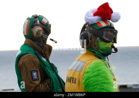 San Diego, États-Unis. 10th décembre 2022. ÉTATS-UNIS L'équipage du pont de la Marine, le lieutenant Jace Cox, à droite, s'habille en costume de Noël alors qu'il observe la position de l'avion pour le décollage sur le pont de vol du porte-avions USS Abraham Lincoln, 10 décembre 2022 au large de la côte de Californie. Crédit: MC3 Ian Thomas/Planetpix/Alamy Live News crédit: Planetpix/Alamy Live News Banque D'Images