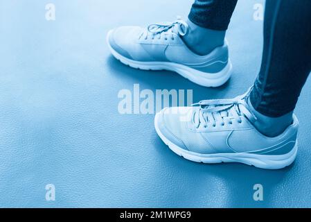 Voir les jambes de femme portant des chaussures de sport dans la salle de sport avec copie espace Banque D'Images